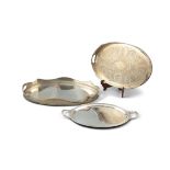 A COLLECTION OF THREE LARGE SILVER PLATED OVAL TWO-HANDLED SERVING TRAYS. The largest 61 x 41cm