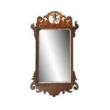 A GEORGE III STYLE MAHOGANY FRETWORK AND PARCEL GILT MIRROR, the pierced frame with ho-ho bird