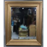 A large gilt frame rectangular wall mirror with raised foliate border & inset bevelled plate, 40”