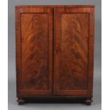 A 19th century mahogany dwarf cabinet with fitted interior enclosed by pair of panel doors, & on bun