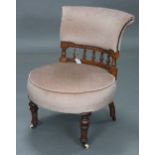 A Victorian mahogany-frame nursing chair with padded seat & back upholstered pink velour, & on short