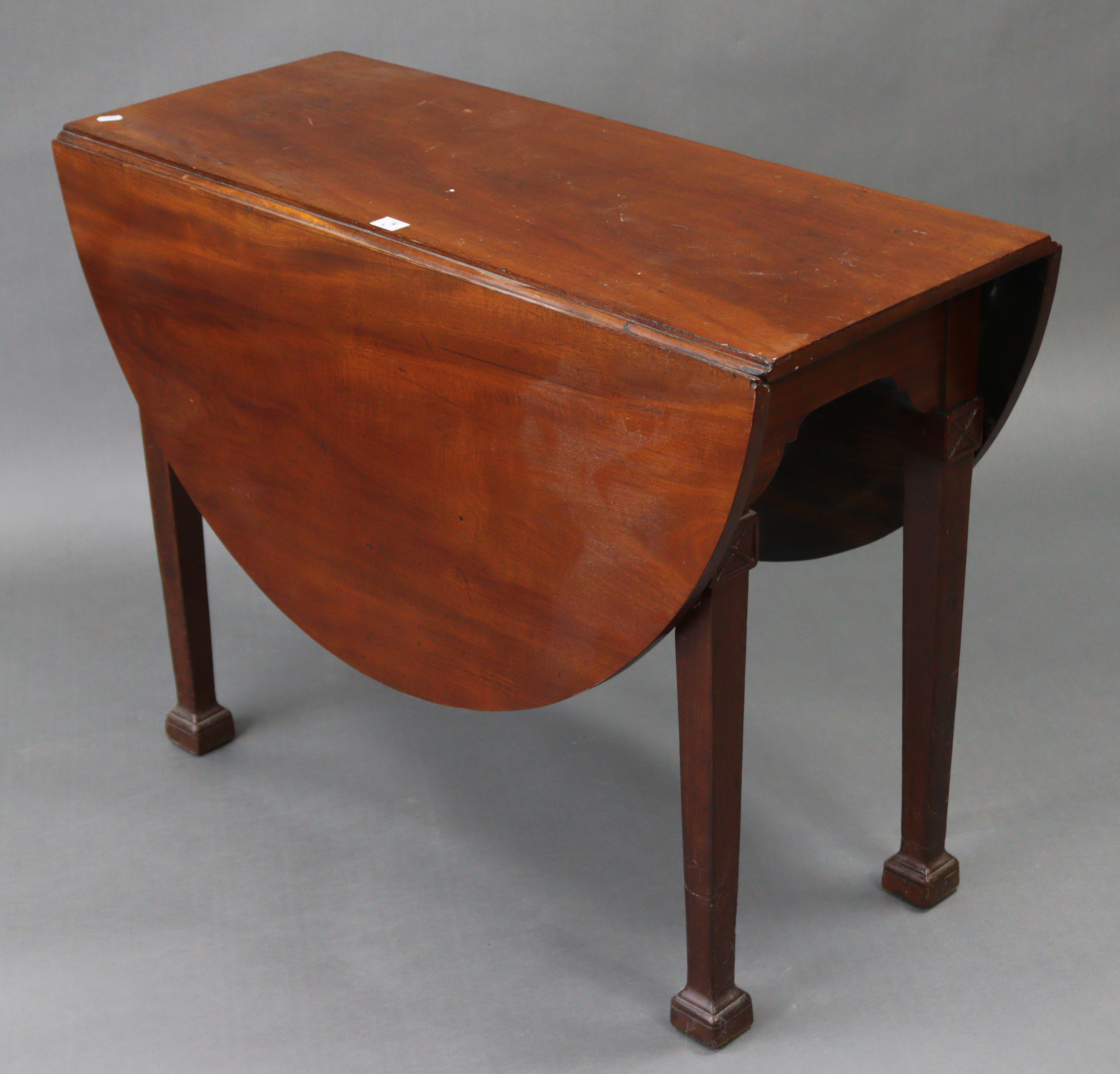 A late 19th/early 20th century mahogany drop-leaf dining table with D-shaped ends, & on square