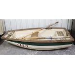A fibreglass & wooden rowing boat “Coco” , 71” long, complete with a pair of oars.