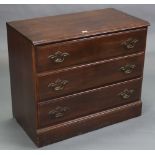 A mahogany-finish dwarf chest, fitted three long drawers with brass swing handles, & on plinth base,