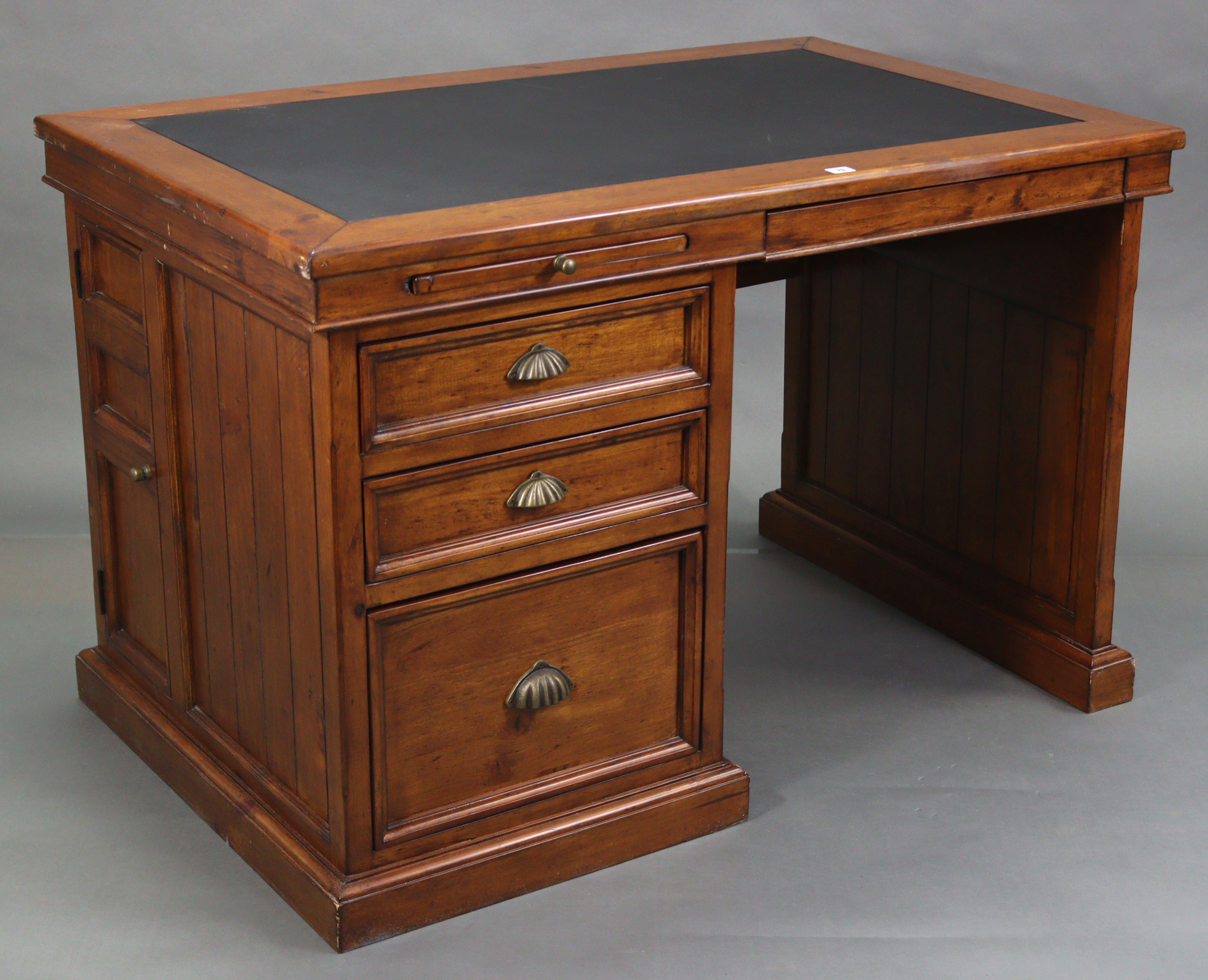 A stained pine office desk, inset black leatherette to the rectangular top, fitted two brushing