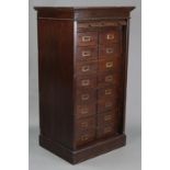 An early 20th century oak upright office filing cabinet, fitted two ranks of eight long drawers