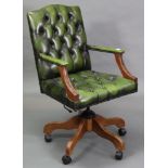 A buttoned green leather & brass-studded swivel desk chair, on five shaped legs with castors.