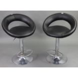 A pair of chrome-finish bar stools with black vinyl seats & backs; three modern rugs; & various