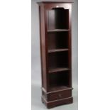 A hardwood tall standing open four-tier bookcase, fitted with a long drawer below & on shaped plinth