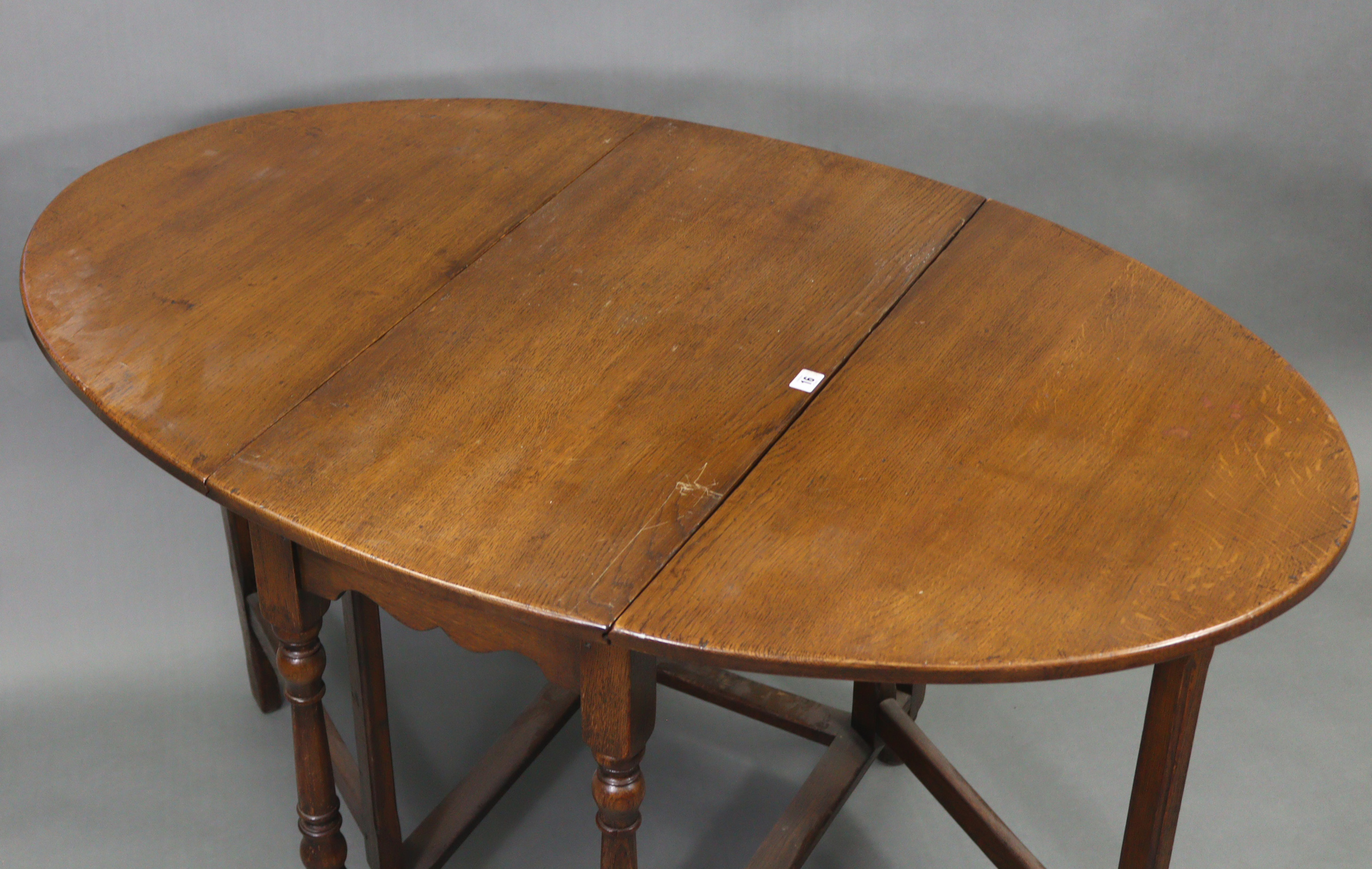 An oak oval gate-leg dining table on baluster-turned legs & turned feet with plain stretchers, 33” x - Image 3 of 3