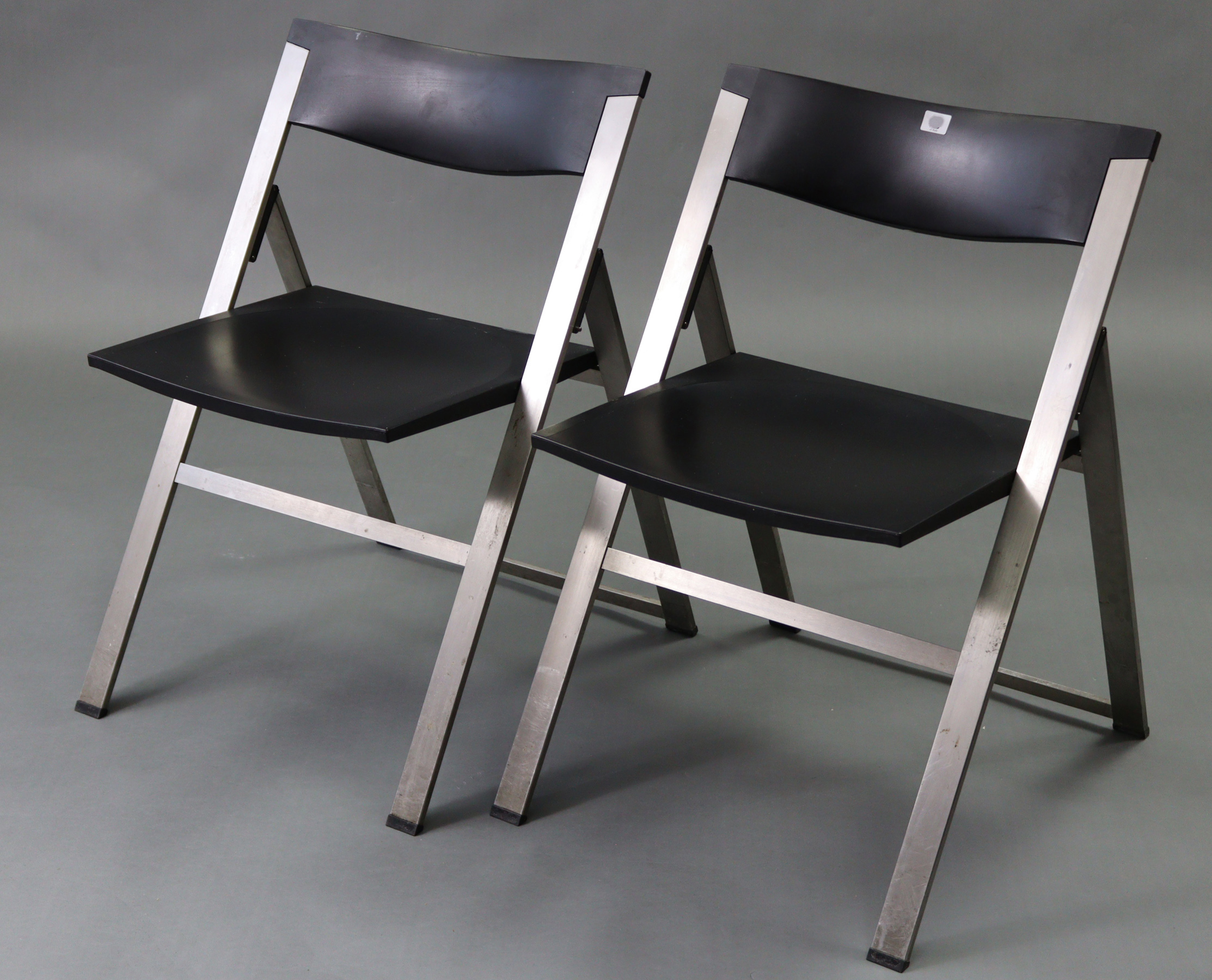A pair of silvered-metal & black plastic fold-away chairs after a design by Justus Kolburg.