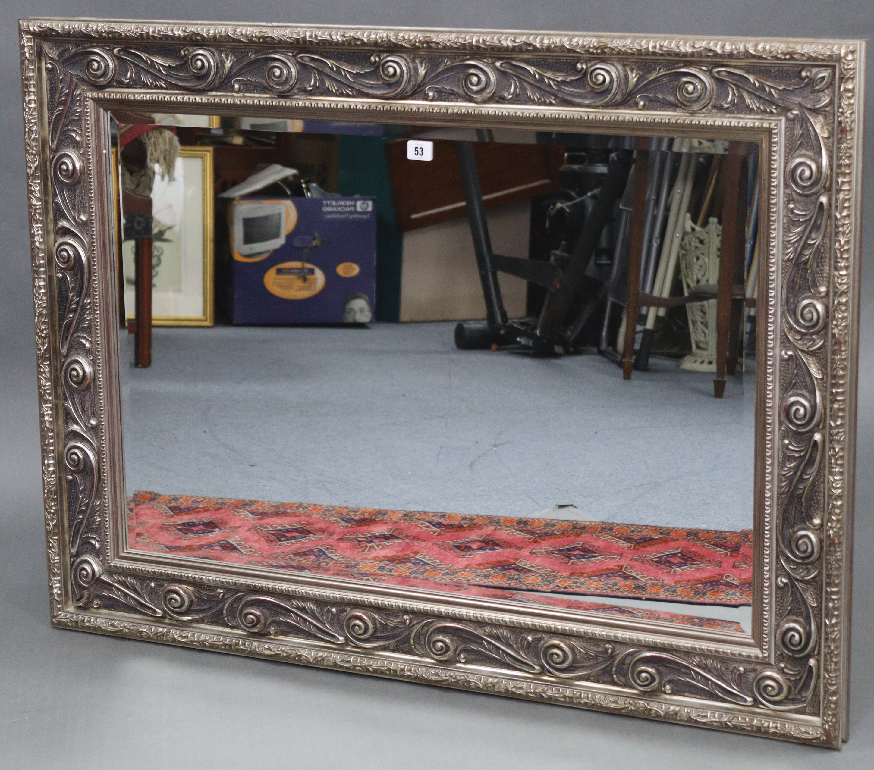 A large rectangular wall mirror with silvered ornate frame, & inset bevelled plate, 32” x 43½”.