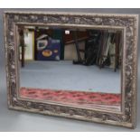 A large rectangular wall mirror with silvered ornate frame, & inset bevelled plate, 32” x 43½”.
