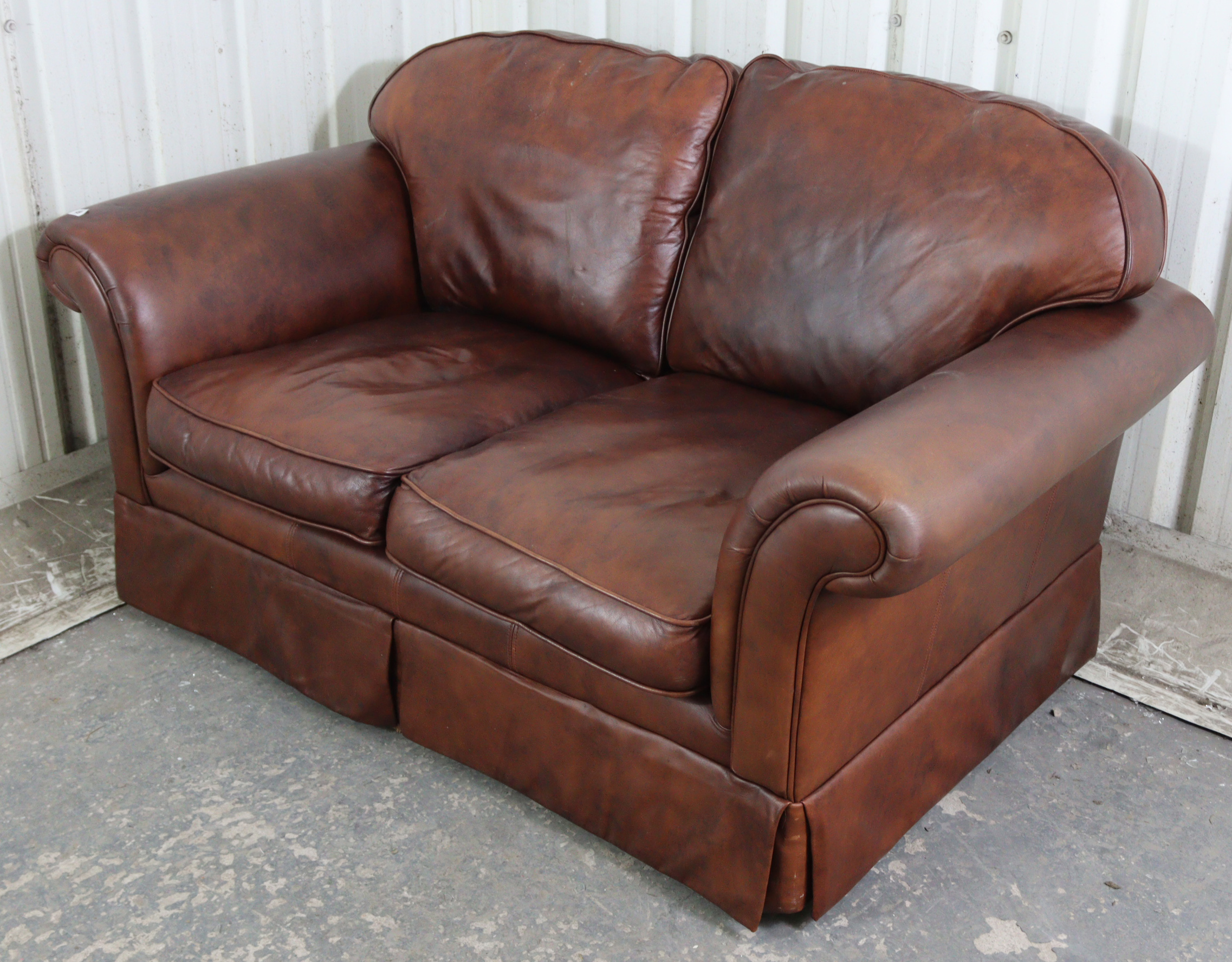 A tan leather three-piece lounge suite comprising of a two-seater settee, 59” long, & a pair of