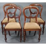 A set of four Victorian mahogany balloon-back dining chairs, with padded drop-in seats & on