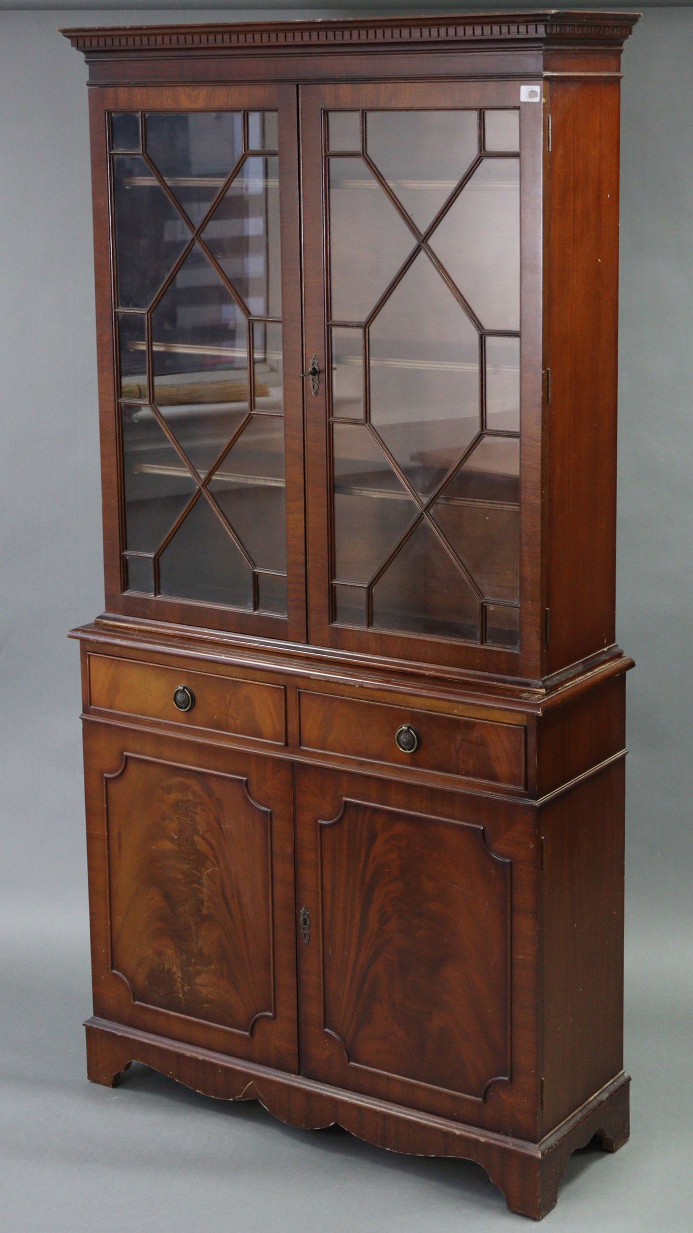 A reproduction mahogany tall standing bookcase, the upper part with three adjustable shelves