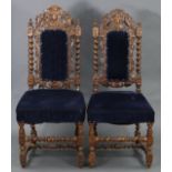 A pair of early 20th century carved oak hall chairs in the Carolean-style.