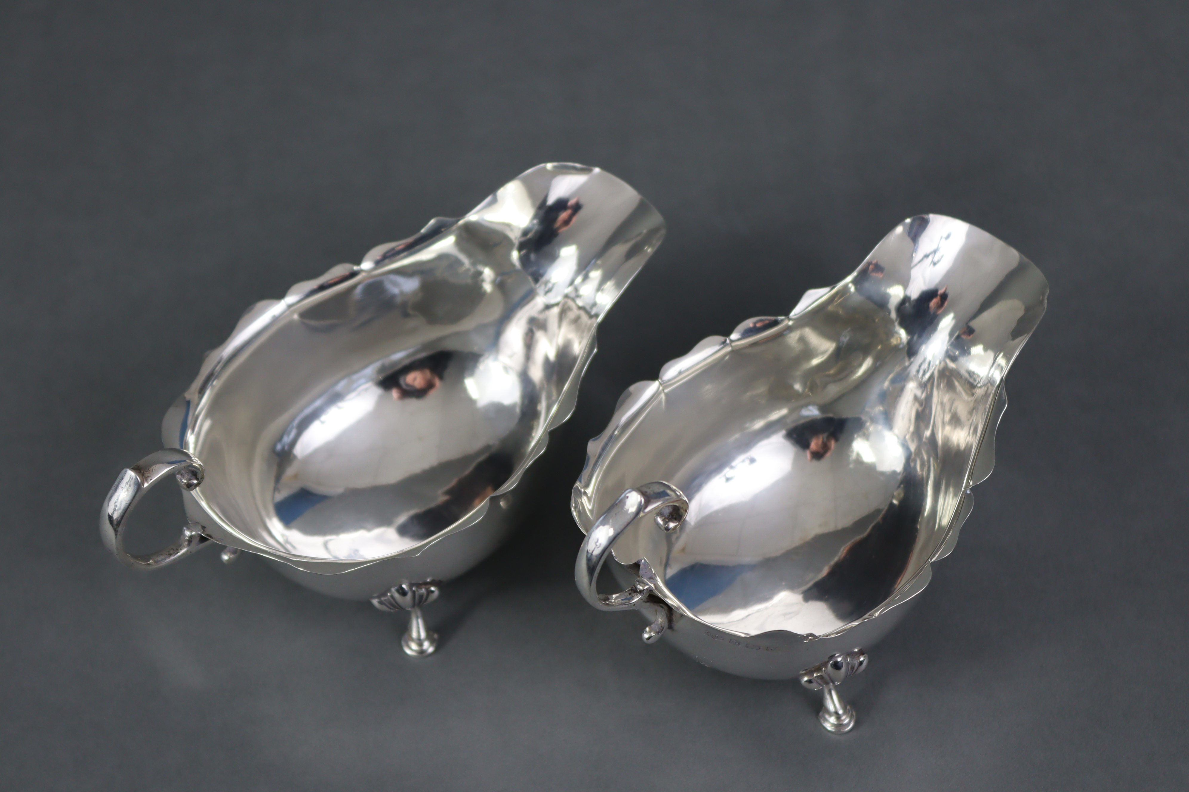 A pair of Georgian-style silver sauce boats, each with scroll handle & card-cut rims, on three shell - Image 3 of 5