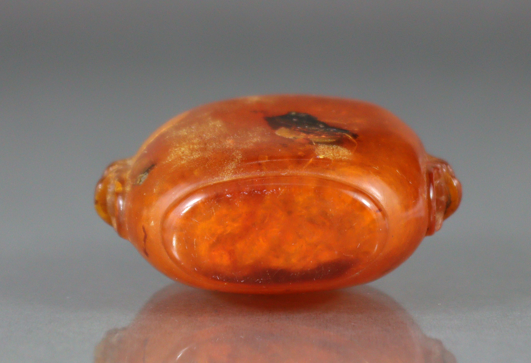 A Chinese carved golden amber snuff bottle of compressed form, with mask-&-ring handles to each - Image 7 of 8