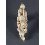 A Japanese netsuke, possibly stag antler, carved in the form of a dragon holding a pearl in its