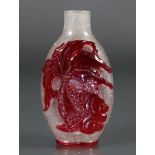 A Chinese red overlay clear glass snuff bottle of ovoid form, the bubble-suffused clear ground