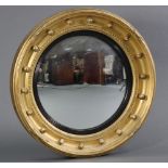 A Regency gilt framed convex wall mirror with ribbon & ball decoration & ebonised inner slip, 22½”