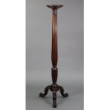 A late 19th century mahogany torchere in the George III style, the fluted & reeded turned column