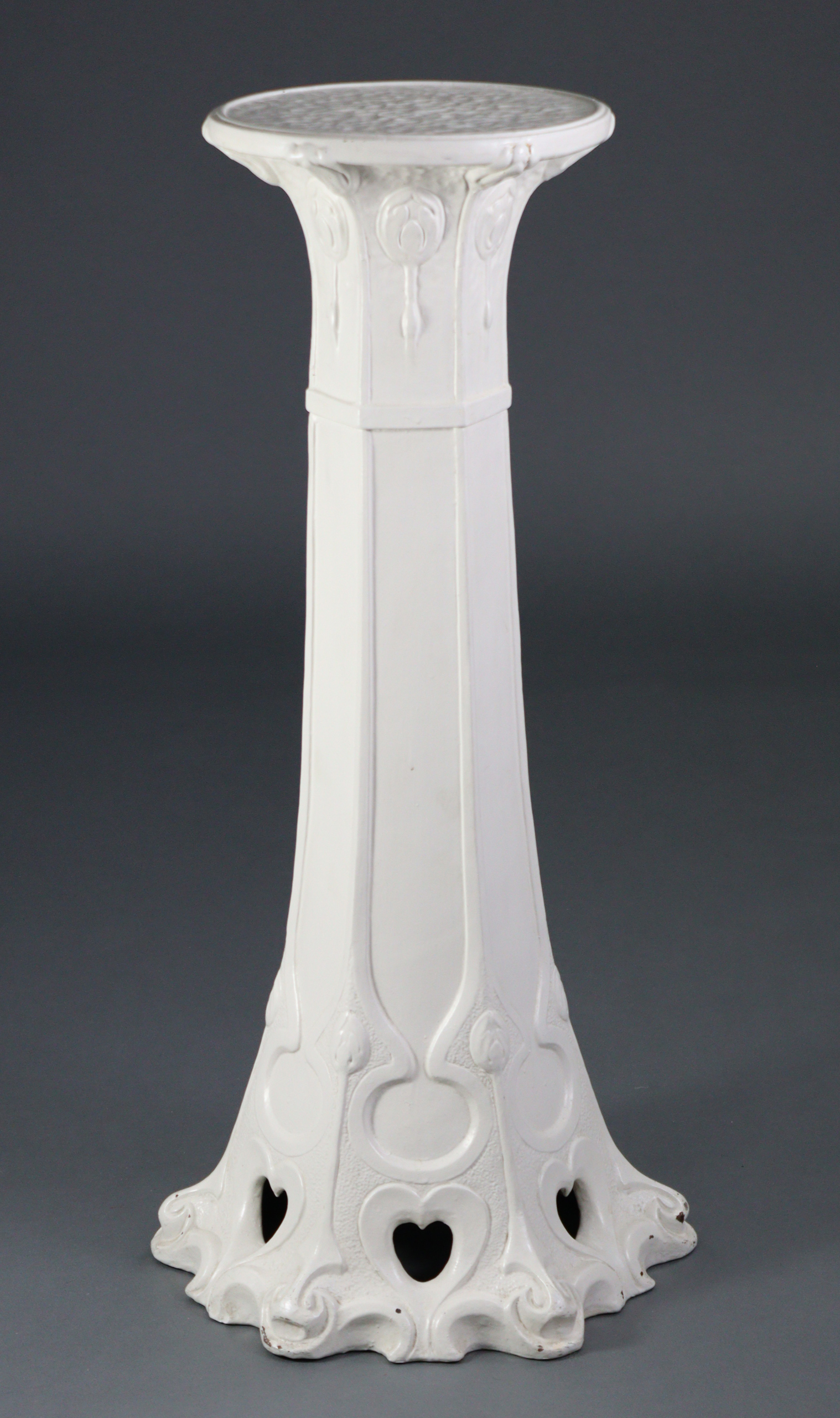 A Bretby Pottery white painted jardiniere stand of hexagonal tapered form with stylised Art