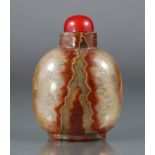 A Chinese agate snuff bottle of rounded form, with vertical striations of varying caramel & white