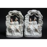 A pair of Staffordshire pottery flat-back models of male & female romantic figure groups; 14”