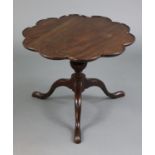 A Georgian mahogany low tripod table with circular top & lobed border, on vase-turned centre