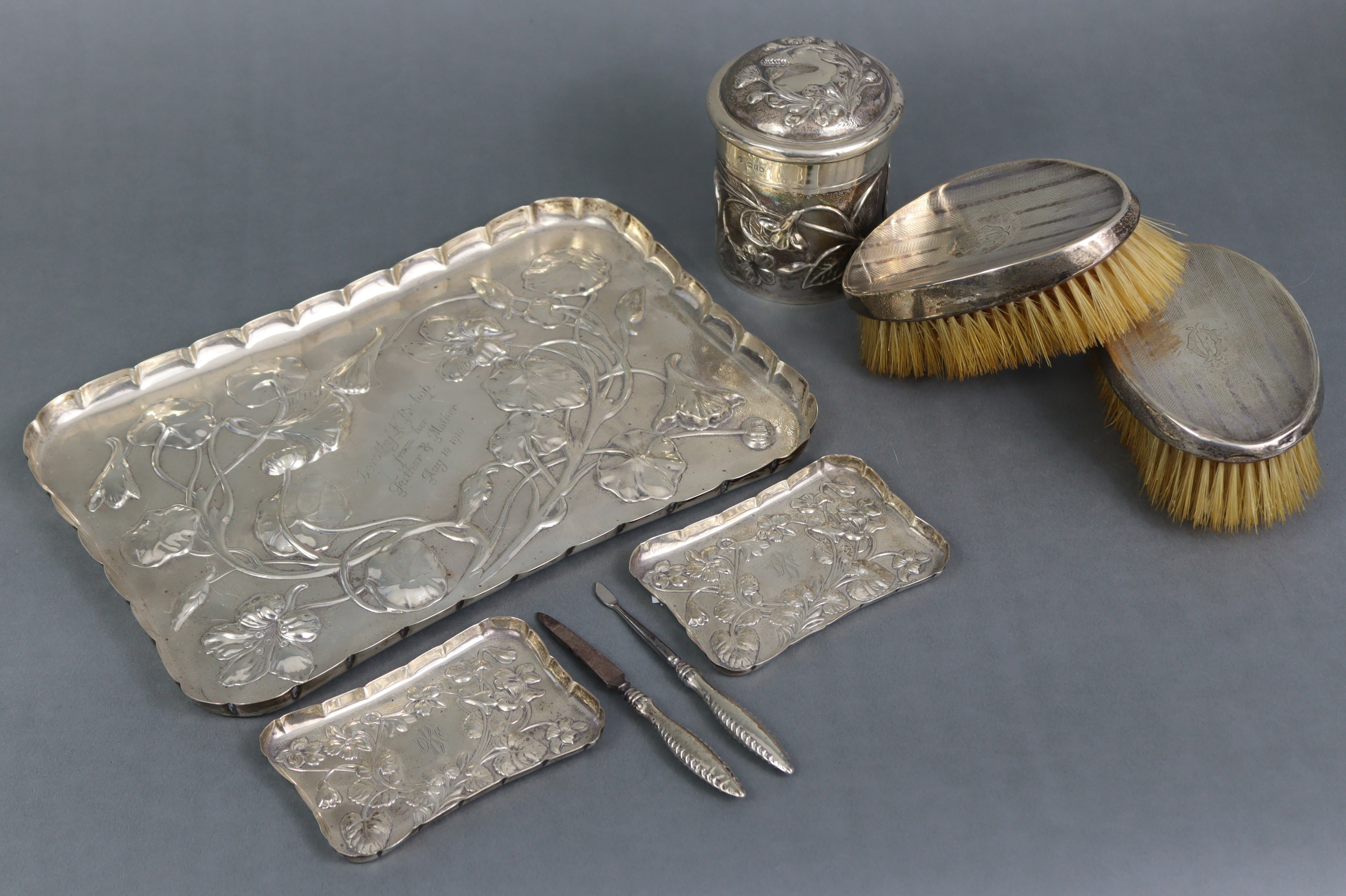 An Edwardian silver dressing table tray with raised crimped border, embossed decoration of