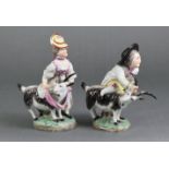 A pair of continental porcelain male & female costume figures, each with a goat & on green mound