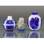 A Chinese overlay glass snuff bottle with carved floral decoration through the blue, green, red,