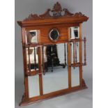 A Victorian walnut overmantel mirror inset an arrangement of six bevelled plates, with shelves on