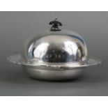 A silver circular muffin dish with ebonised finial to the domed lid, with shaped & reeded