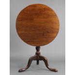 A Georgian mahogany tripod table with circular tilt-top, on vase-turned column with three carved