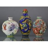 Three Chinese moulded porcelain snuff bottles, the largest decorated with a dragon & phoenix in