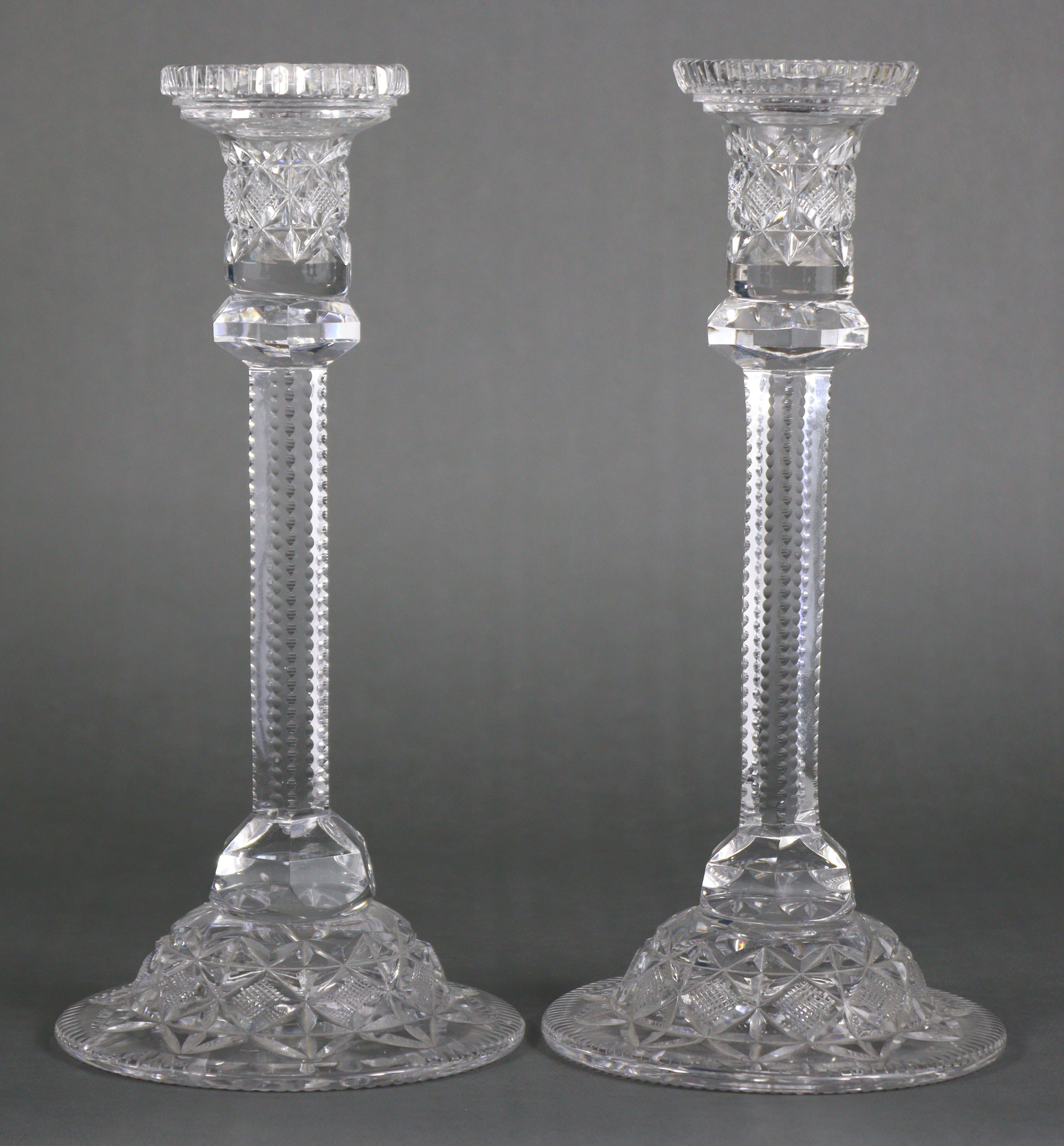 A pair of large cut-glass candlesticks, each with hobnail decoration, hexagonal faceted column, &