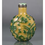 A Chinese yellow glass snuff bottle with green overlay decoration of prunus blossom, pine, bamboo, &