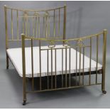 An Edwardian brass double bedstead, with stylised terminals to the head & foot board, complete