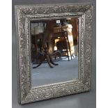 A large rectangular wall mirror in silvered-finish frame with raised geometric border, & inset