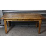 A light oak dining table with rectangular top, fitted two drawers to one side, & on square tapered