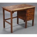 A mid-20th century oak typist’s desk, fitted with a brushing slide above three long drawers to the