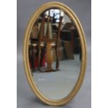 A late 19th/early 20th century gilt-gesso frame oval wall mirror with egg-&-dart border, & inset