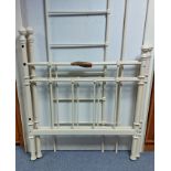 A Victorian-style white-finish tubular-metal single bedstead.