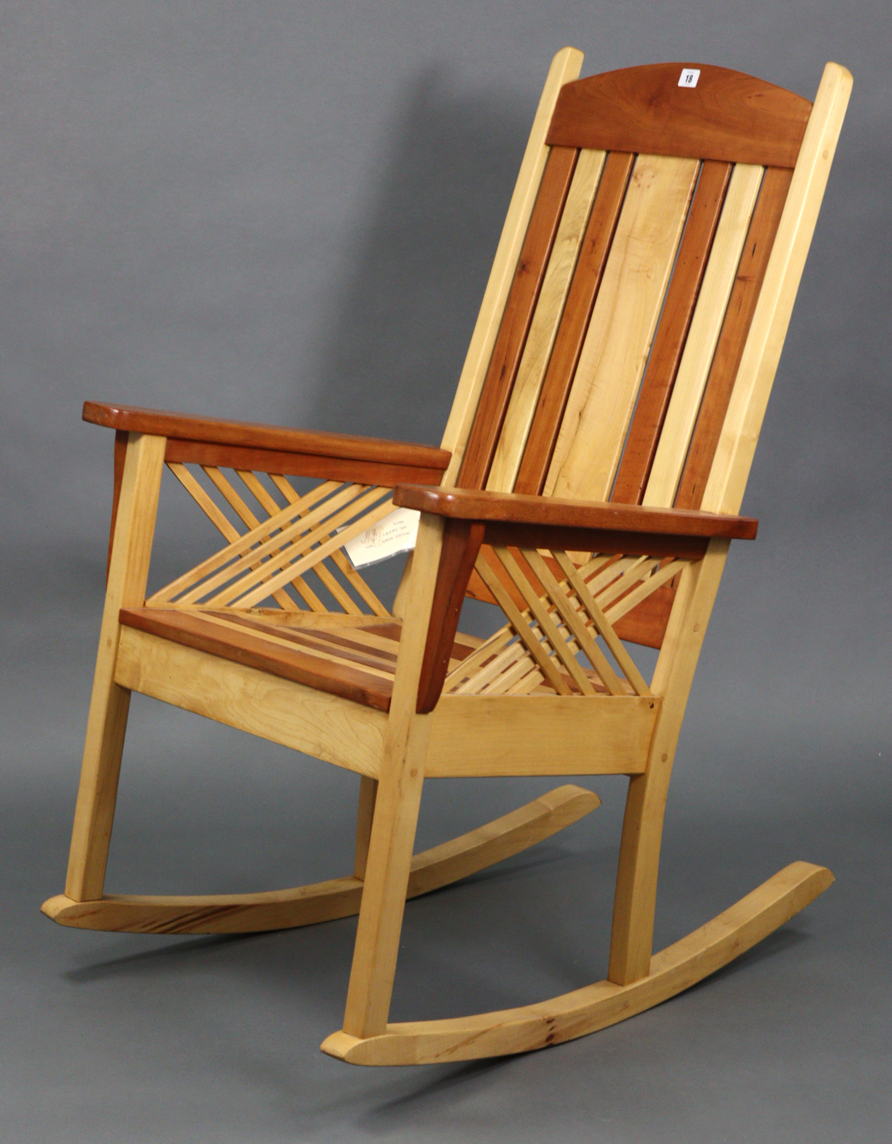 A Tamarack maple & cherry wood rocking chair with slatted seat & back, & on square supports.