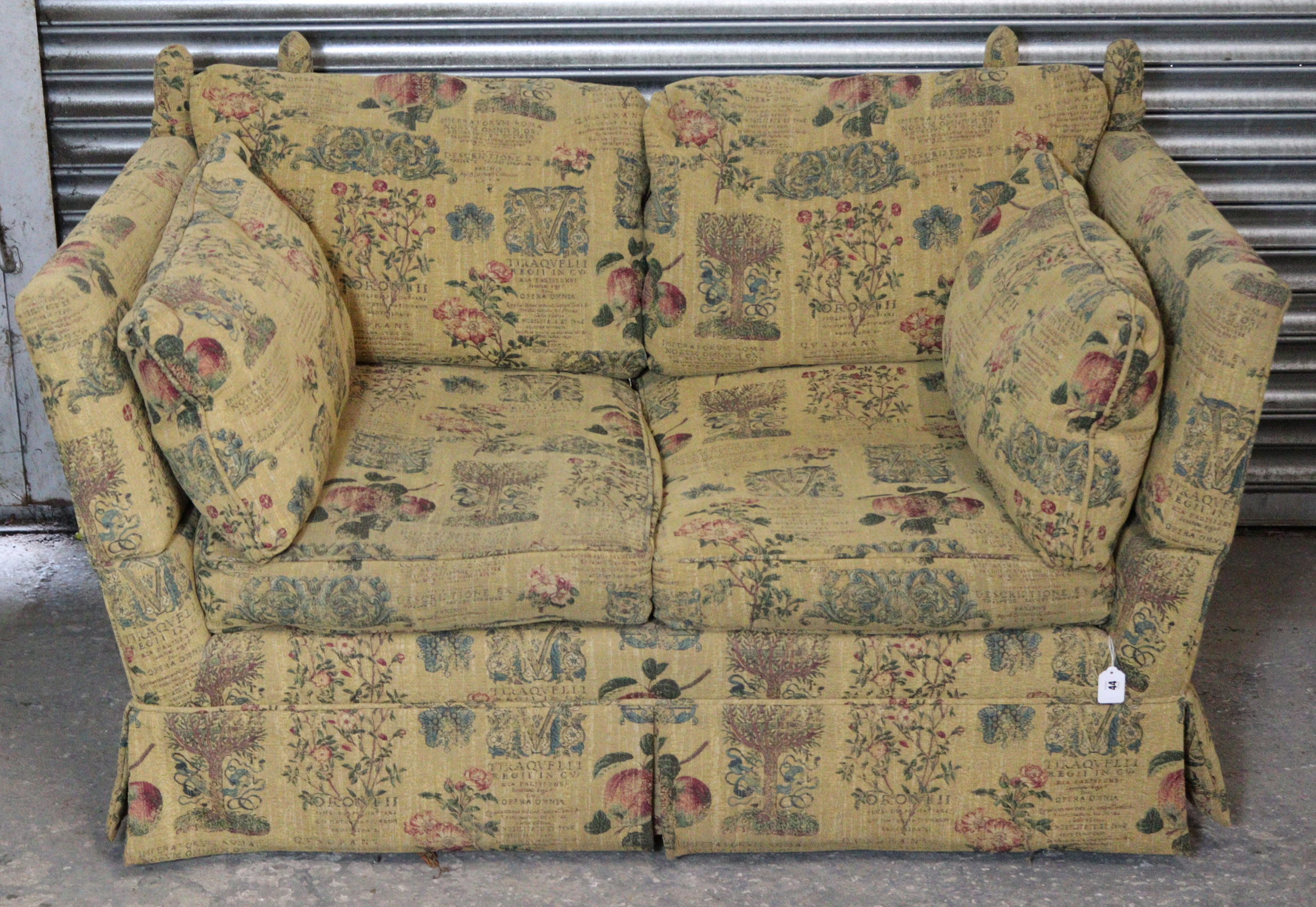 A Knole-style two-seater settee, upholstered cream material & with all-over repeating