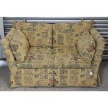 A Knole-style two-seater settee, upholstered cream material & with all-over repeating