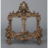 A Victorian gilded cast-metal twin photograph frame with pierced scroll border & decorated with
